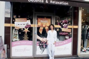 Eugénie, devant la vitrine qui vous rappelle que des cartes et des coffrets cadeaux sont disponibles pour les fêtes.